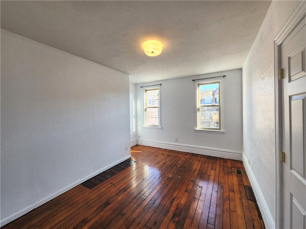 5330 Butler Street, Unit LOFT Pittsburgh, PA 15201 - Photo 3 of 6 a view of an empty room with wooden floor and a window