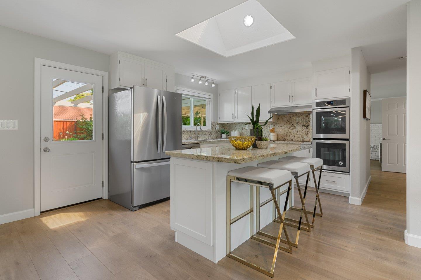 2425 Whitethorne Drive San Jose, CA 95128 - Photo 12 of 48 a kitchen with stainless steel appliances granite countertop a refrigerator a stove a sink a dining table and chairs with wooden floor