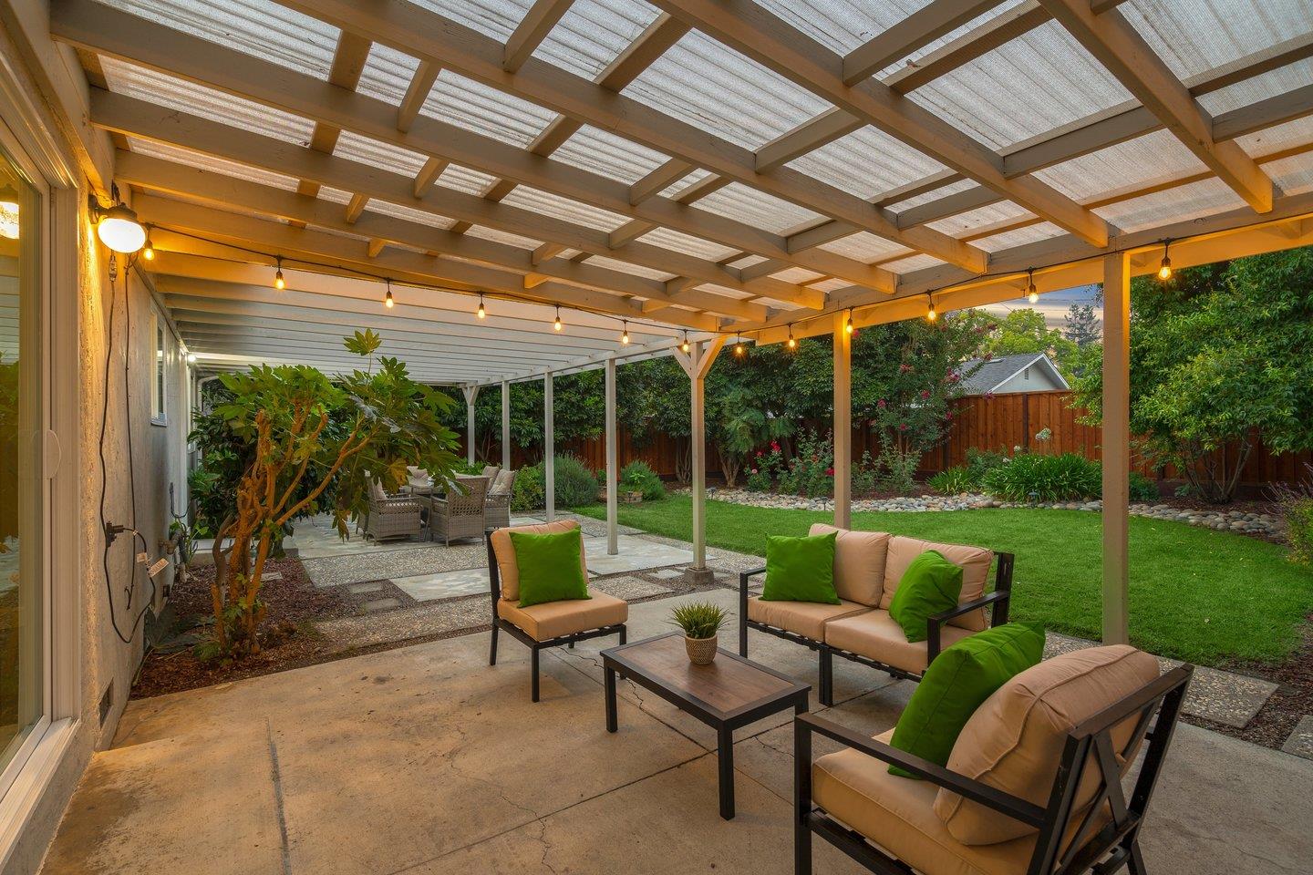 2425 Whitethorne Drive San Jose, CA 95128 - Photo 43 of 48 a view of a patio with couches and table and chairs with wooden floor next to a yard