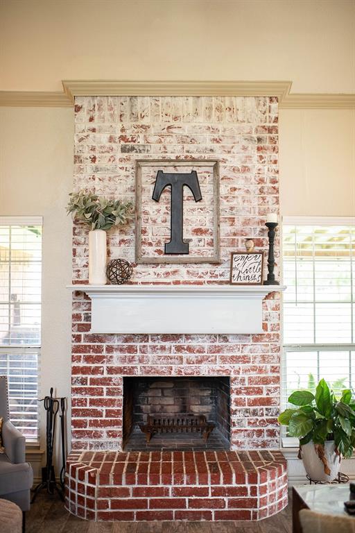10336 Jennifer Circle Forney, TX 75126 - Photo 6 of 37 Gather in the warnth of the inviting living area featuring a floor-to-ceiling brick wood burning fireplace, beautifully finished with a classic white wood mantel.