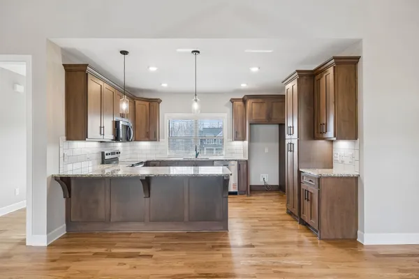 a large kitchen with kitchen island a sink counter top stainless steel appliances and cabinets