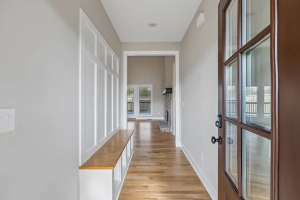 a view of a hallway with wooden floor and staircase