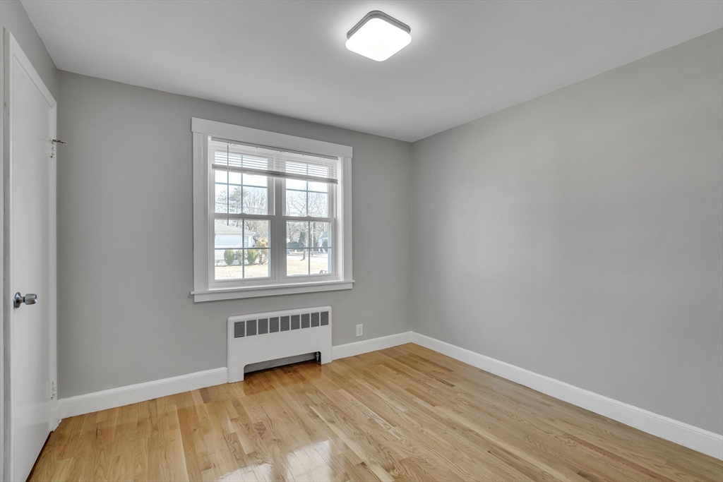 99 Truman Road Newton, MA 02459 - Photo 11 of 26 a view of an empty room with wooden floor and a window