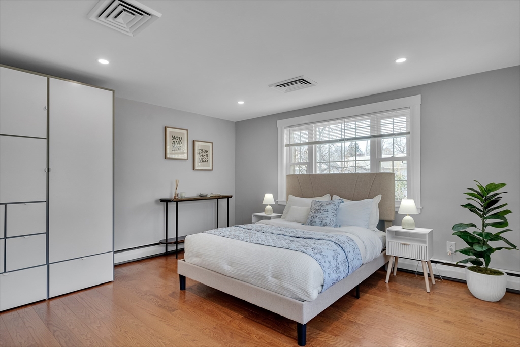 99 Truman Road Newton, MA 02459 - Photo 12 of 26 a bedroom with a large bed and a potted plant