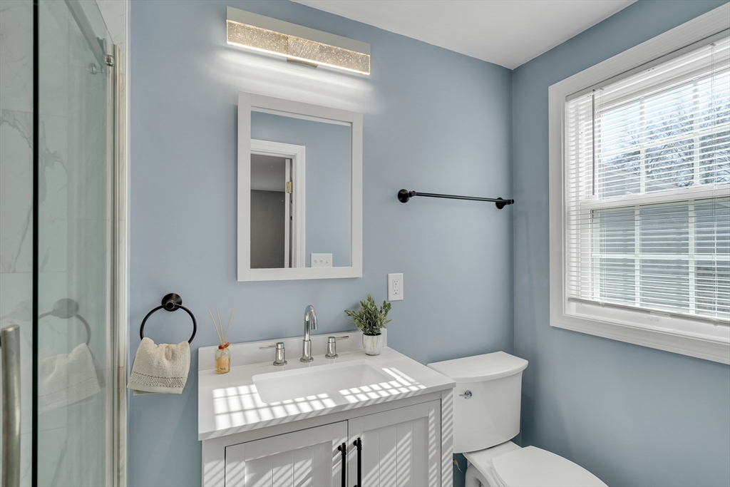 99 Truman Road Newton, MA 02459 - Photo 14 of 26 a bathroom with a granite countertop sink toilet a mirror and window