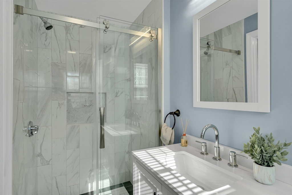 99 Truman Road Newton, MA 02459 - Photo 15 of 26 a bathroom with a granite countertop sink a shower and a mirror