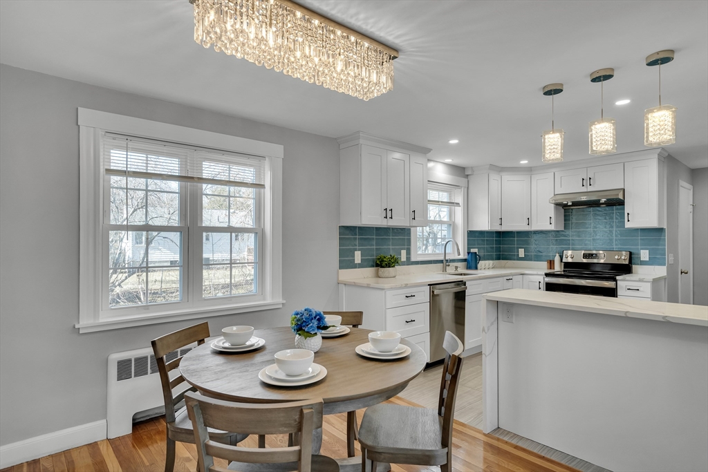 99 Truman Road Newton, MA 02459 - Photo 4 of 26 a kitchen with stainless steel appliances granite countertop a stove a sink a stove a dining table and chairs