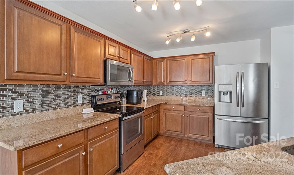 2532 Spring Breeze Way Monroe, NC 28110 - Photo 4 of 21 a kitchen with stainless steel appliances granite countertop a refrigerator sink and cabinets