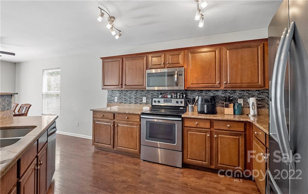 2532 Spring Breeze Way Monroe, NC 28110 - Photo 5 of 21 a kitchen with stainless steel appliances granite countertop a stove a sink dishwasher and a refrigerator