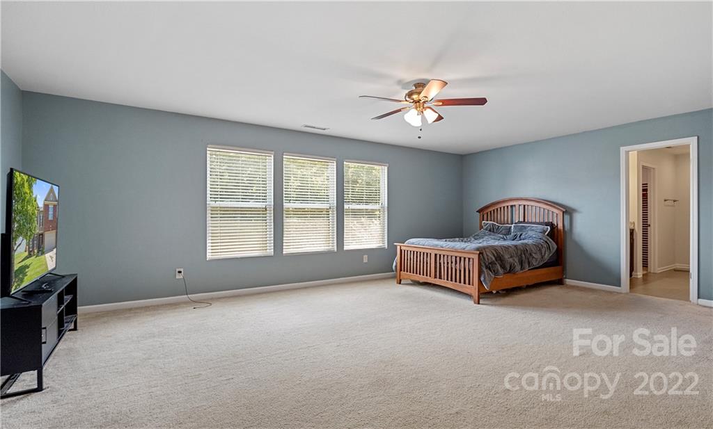 2532 Spring Breeze Way Monroe, NC 28110 - Photo 10 of 21 a spacious bedroom with a bed and a ceiling fan