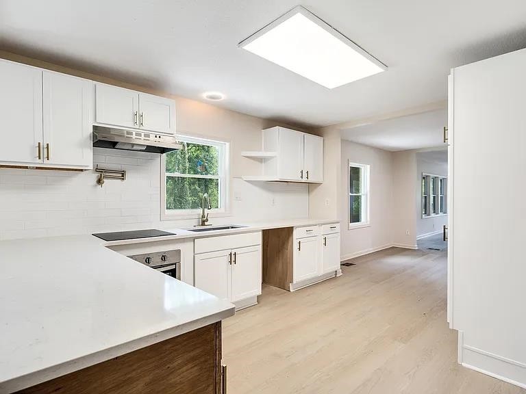 a kitchen with stainless steel appliances granite countertop a stove a sink dishwasher and a refrigerator