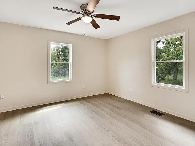 7441 Walsh Road Millington, TN 38053 - Photo 9 of 16 a view of an empty room with wooden floor and a window