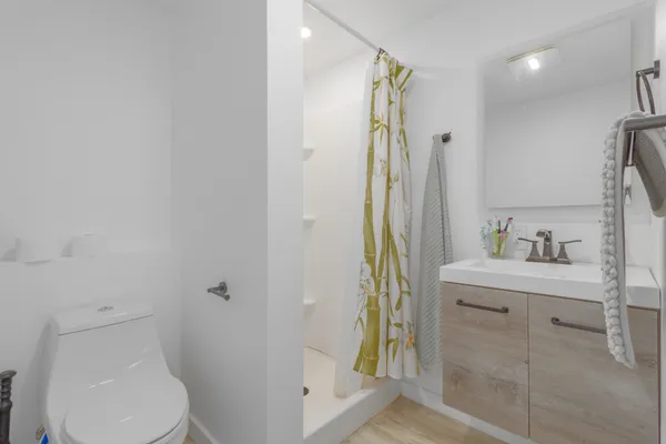 a bathroom with a sink a toilet and shower
