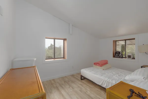 a bedroom with a bed and wooden floor