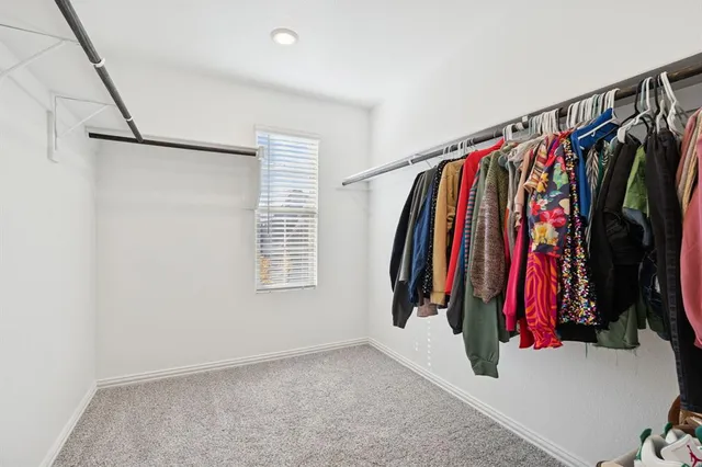 a view of walk in closet with clothes