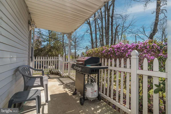 a view of a patio with table and chairs and wooden fence