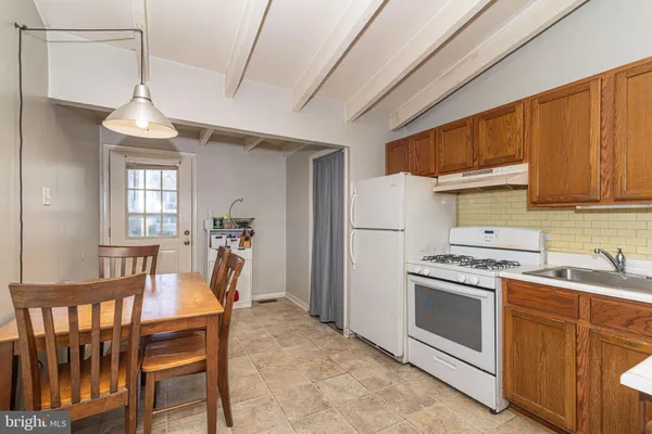 a kitchen that has a stove a table and chairs in it