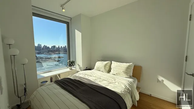 a bedroom with a bed and a large window