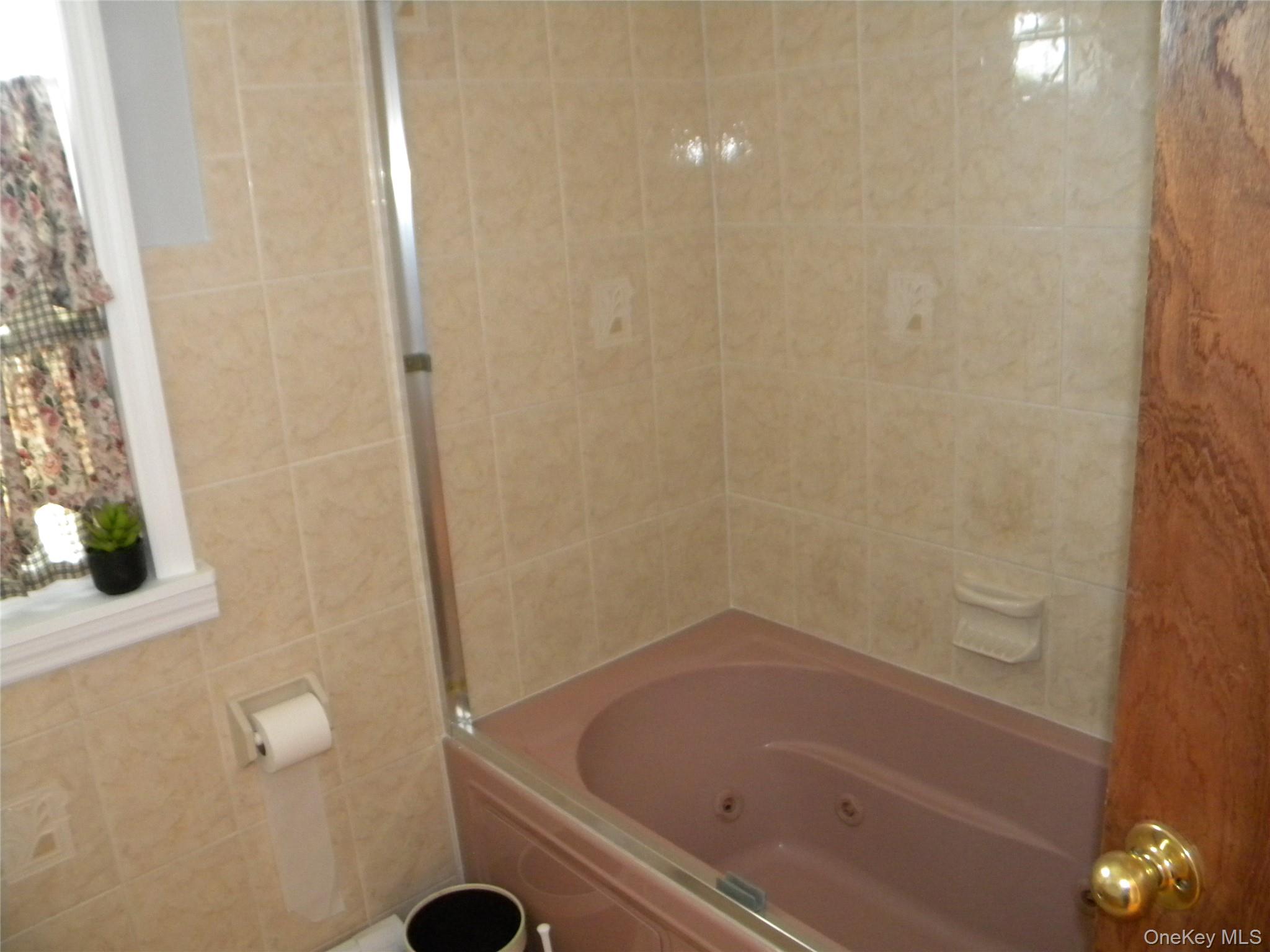 241-26 86th Road Queens, NY 11426 - Photo 15 of 38 a bathroom with a bathtub