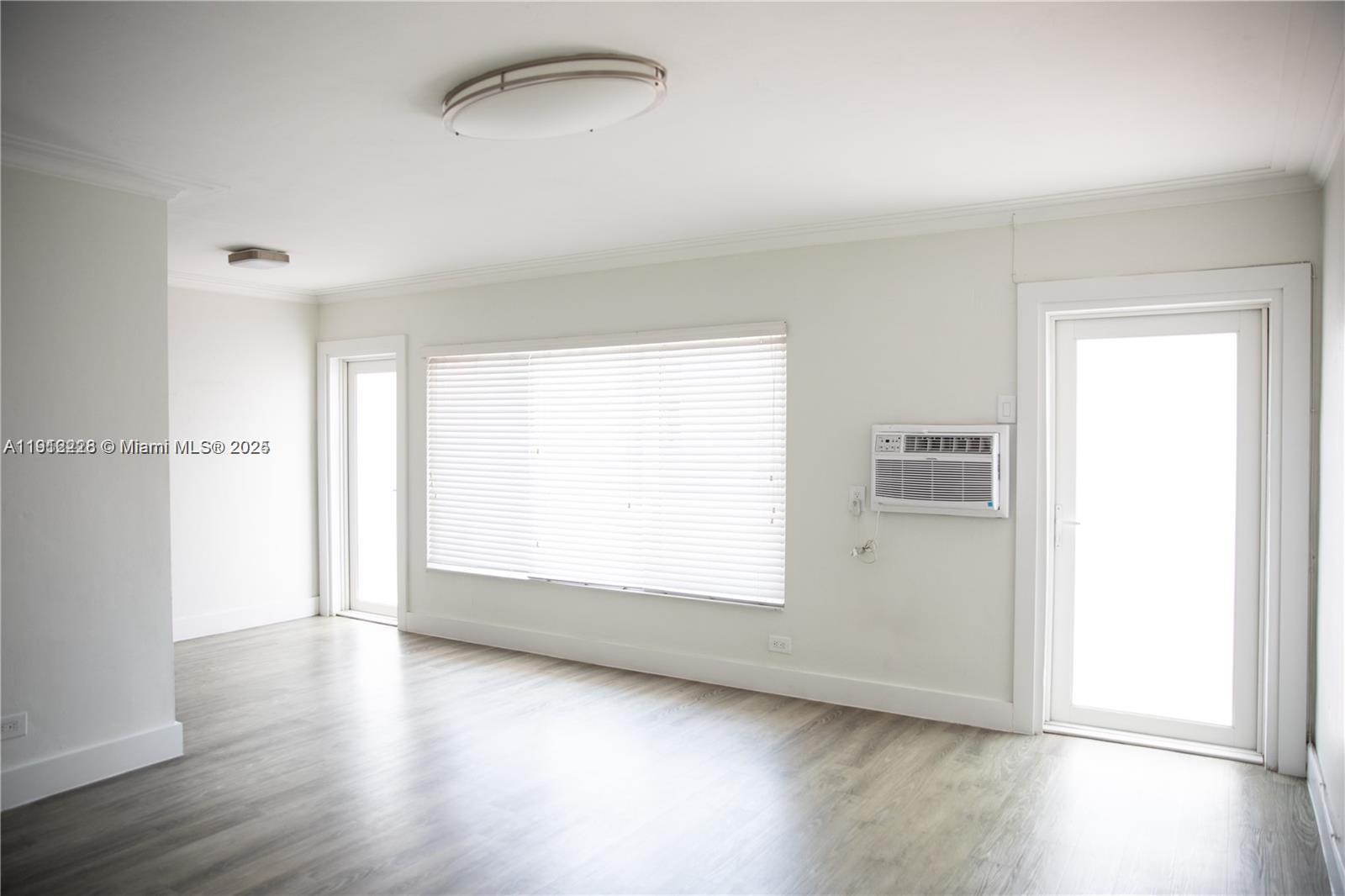 345 85th Street, Unit 2 Miami Beach, FL 33141 - Photo 12 of 13 an empty room with wooden floor and windows
