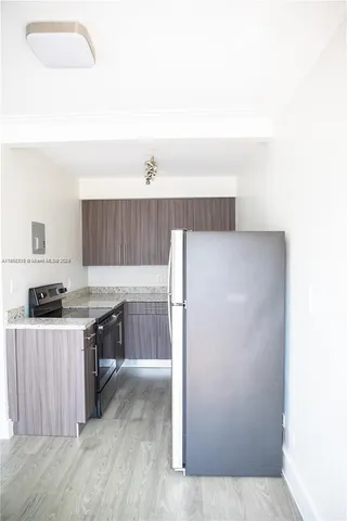a kitchen with a refrigerator sink and cabinets