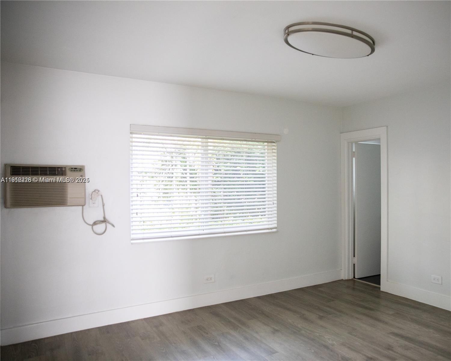 345 85th Street, Unit 2 Miami Beach, FL 33141 - Photo 7 of 13 an empty room with wooden floor and windows