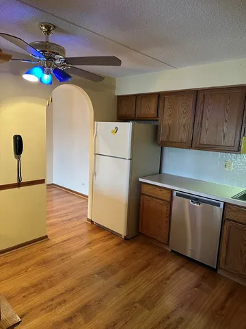 a kitchen with a refrigerator a stove top oven a sink and wooden floor