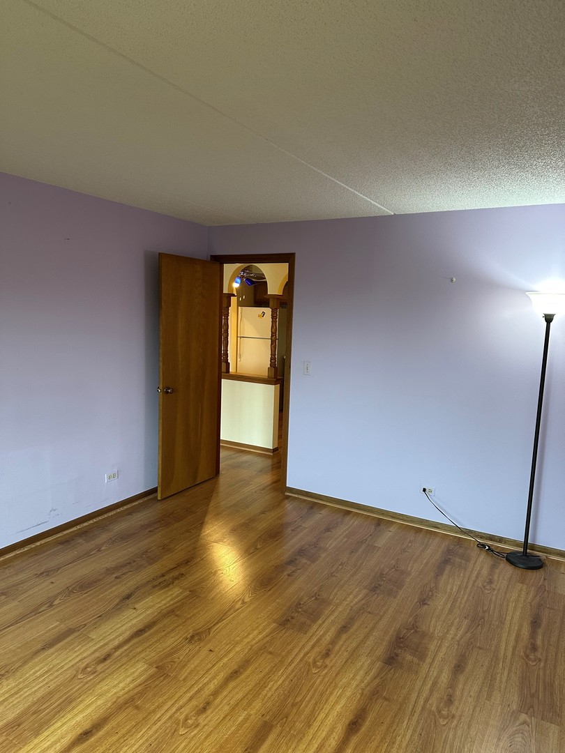 6460 West Belle Plaine Avenue, Unit 407 Chicago, IL 60634 - Photo 7 of 15 wooden floor in an empty room with a window