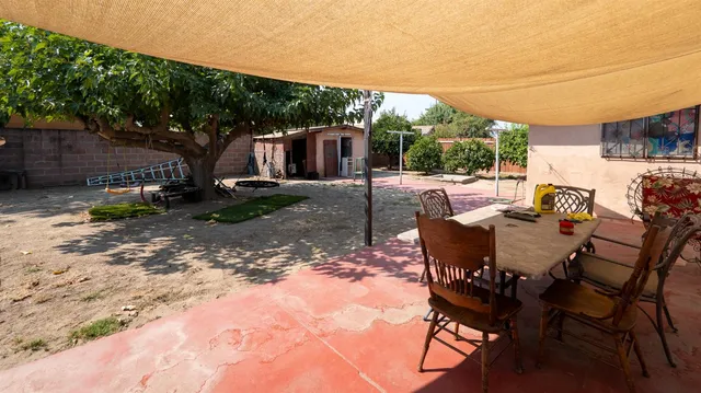 a view of a patio with a table chairs and a backyard