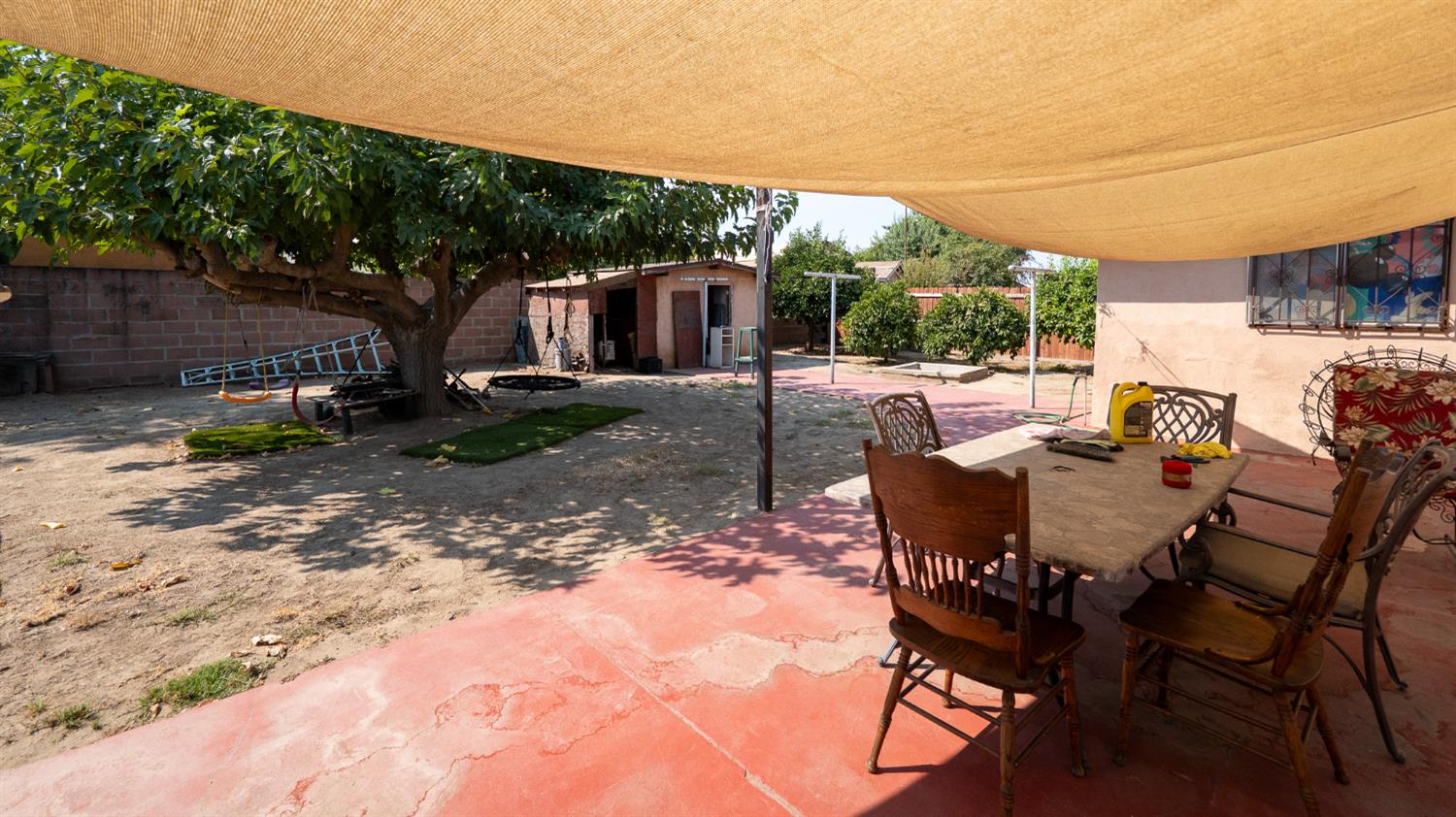 859 11th Street Sanger, CA 93657 - Photo 21 of 28 a view of a patio with a table chairs and a backyard