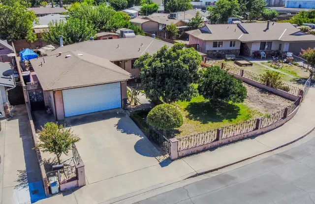 an aerial view of a house with a garden and lake view