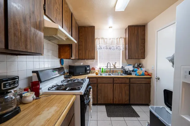 a kitchen with stainless steel appliances a stove a sink a refrigerator and cabinets