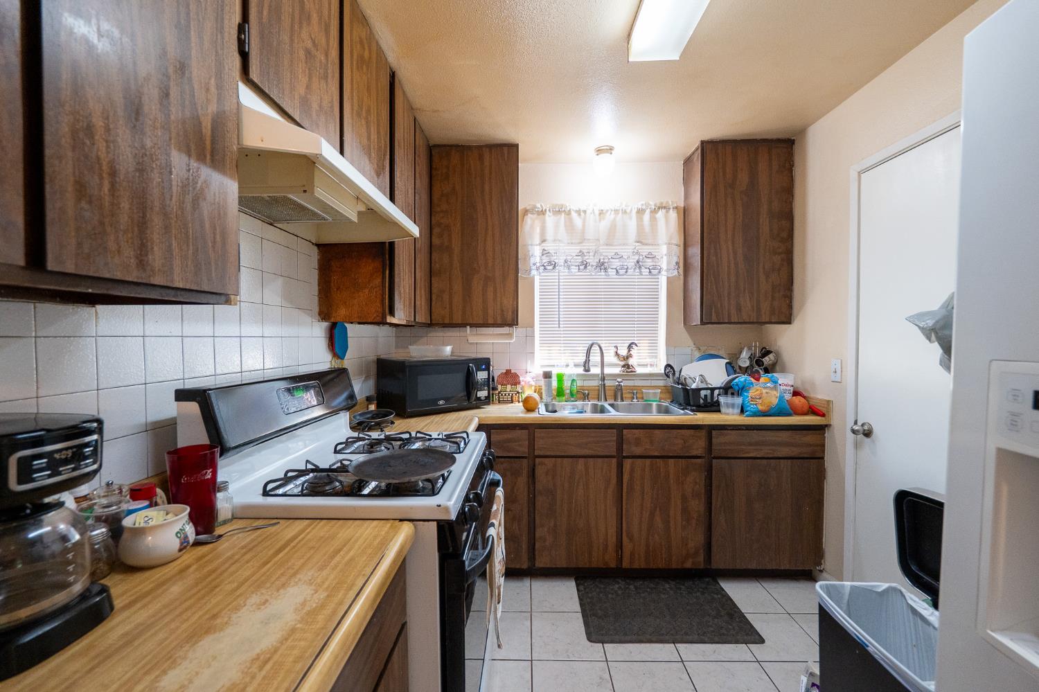 859 11th Street Sanger, CA 93657 - Photo 6 of 28 a kitchen with stainless steel appliances a stove a sink a refrigerator and cabinets