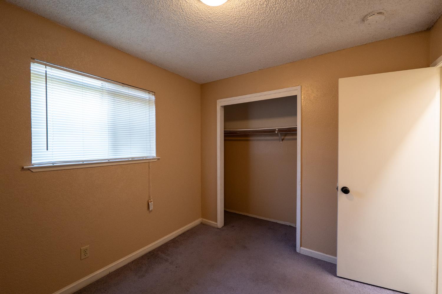 859 11th Street Sanger, CA 93657 - Photo 7 of 28 a view of an empty room with a window