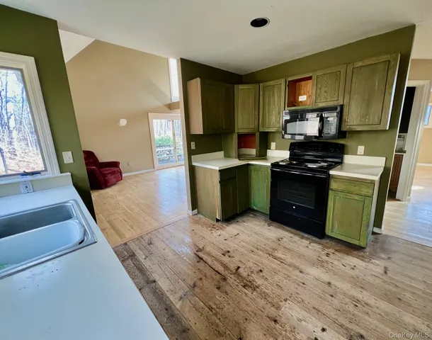 a kitchen with stainless steel appliances granite countertop a stove top oven a sink dishwasher and a refrigerator