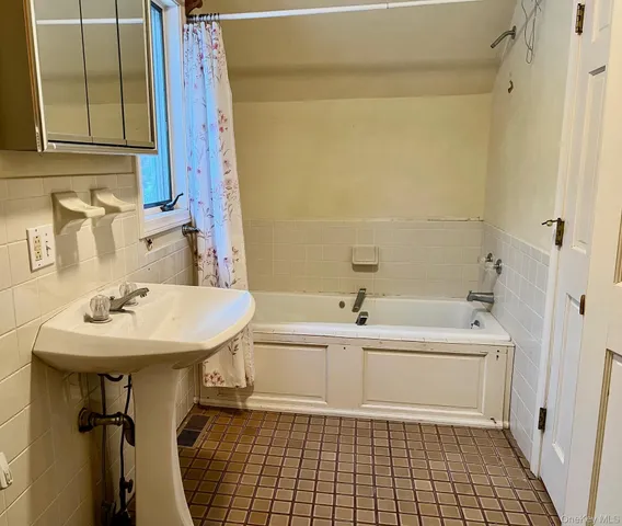 a view of empty room with a window and bathroom