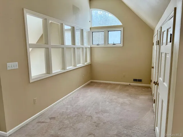 a view of an empty room with a fireplace and a window