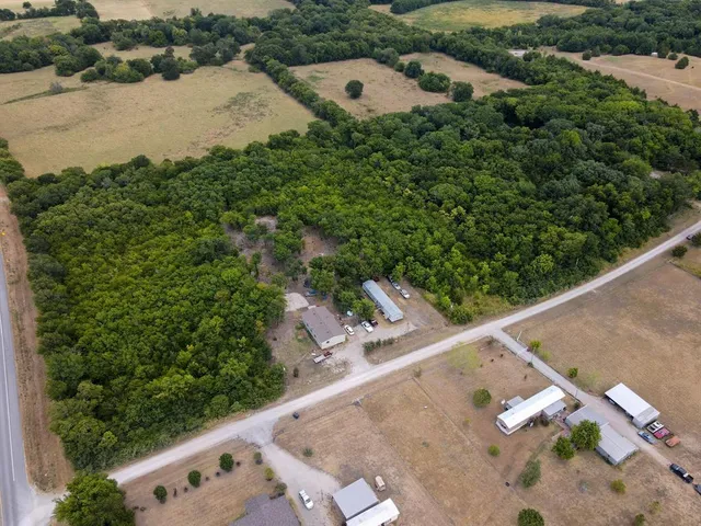an aerial view of a house with yard and lake view