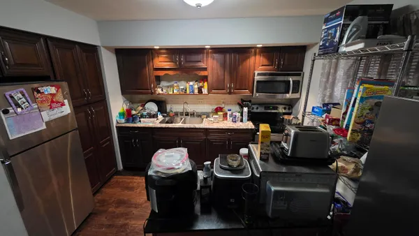 a kitchen with a refrigerator and a stove top oven