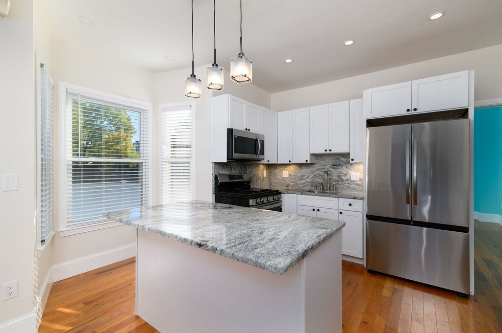 382-384 Adams Street, Unit 3841 Boston, MA 02122 - Photo 5 of 16 a kitchen with stainless steel appliances granite countertop a refrigerator a stove a sink and a microwave