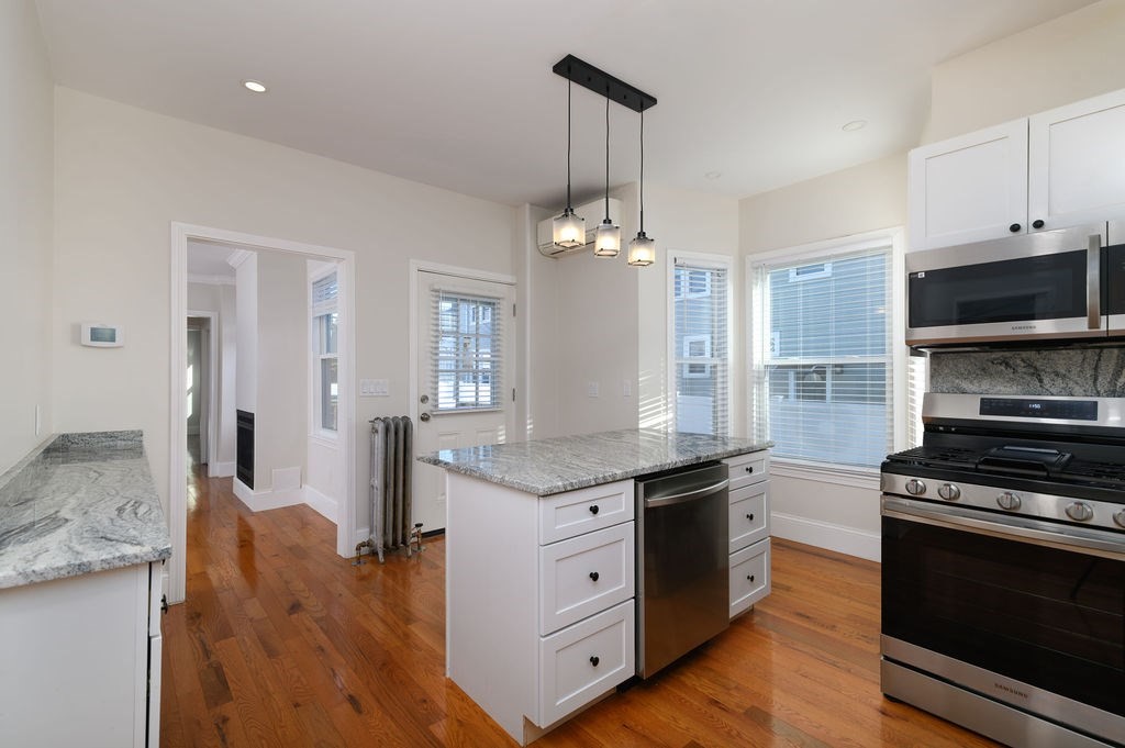 382-384 Adams Street, Unit 3841 Boston, MA 02122 - Photo 8 of 16 a kitchen with stainless steel appliances granite countertop a stove and a sink
