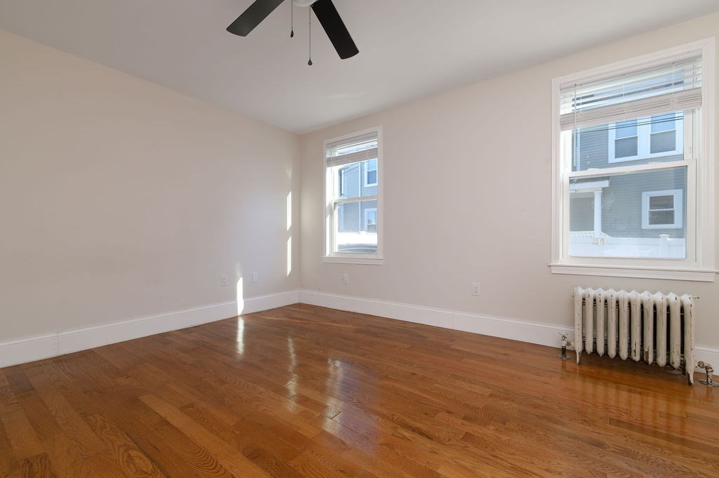 382-384 Adams Street, Unit 3841 Boston, MA 02122 - Photo 10 of 16 an empty room with wooden floor cabinet and windows