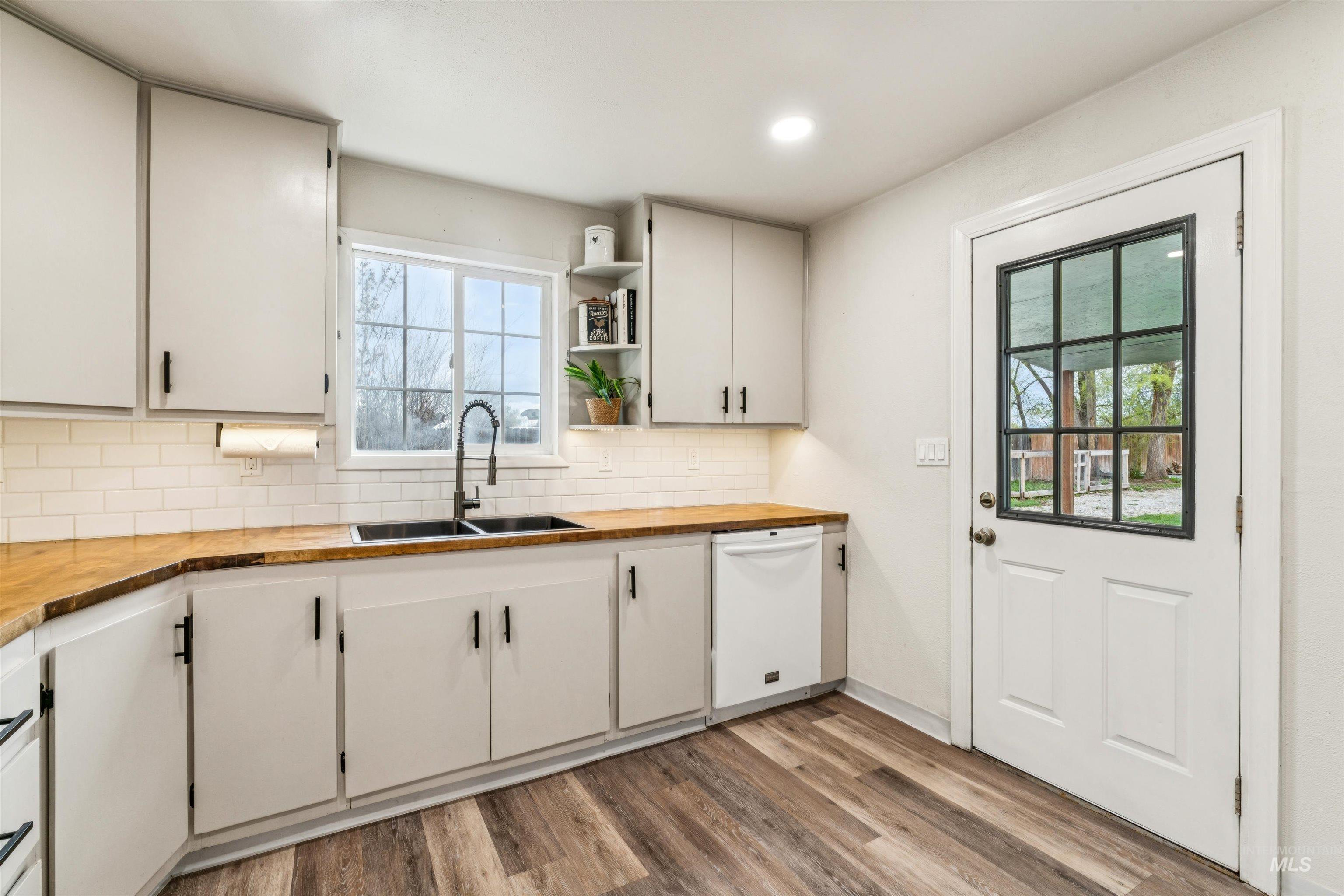 948 South Mill Road Emmett, ID 83617 - Photo 11 of 38 Kitchen with wood counters, dishwasher, light wood-style floors, open shelves, and tasteful backsplash