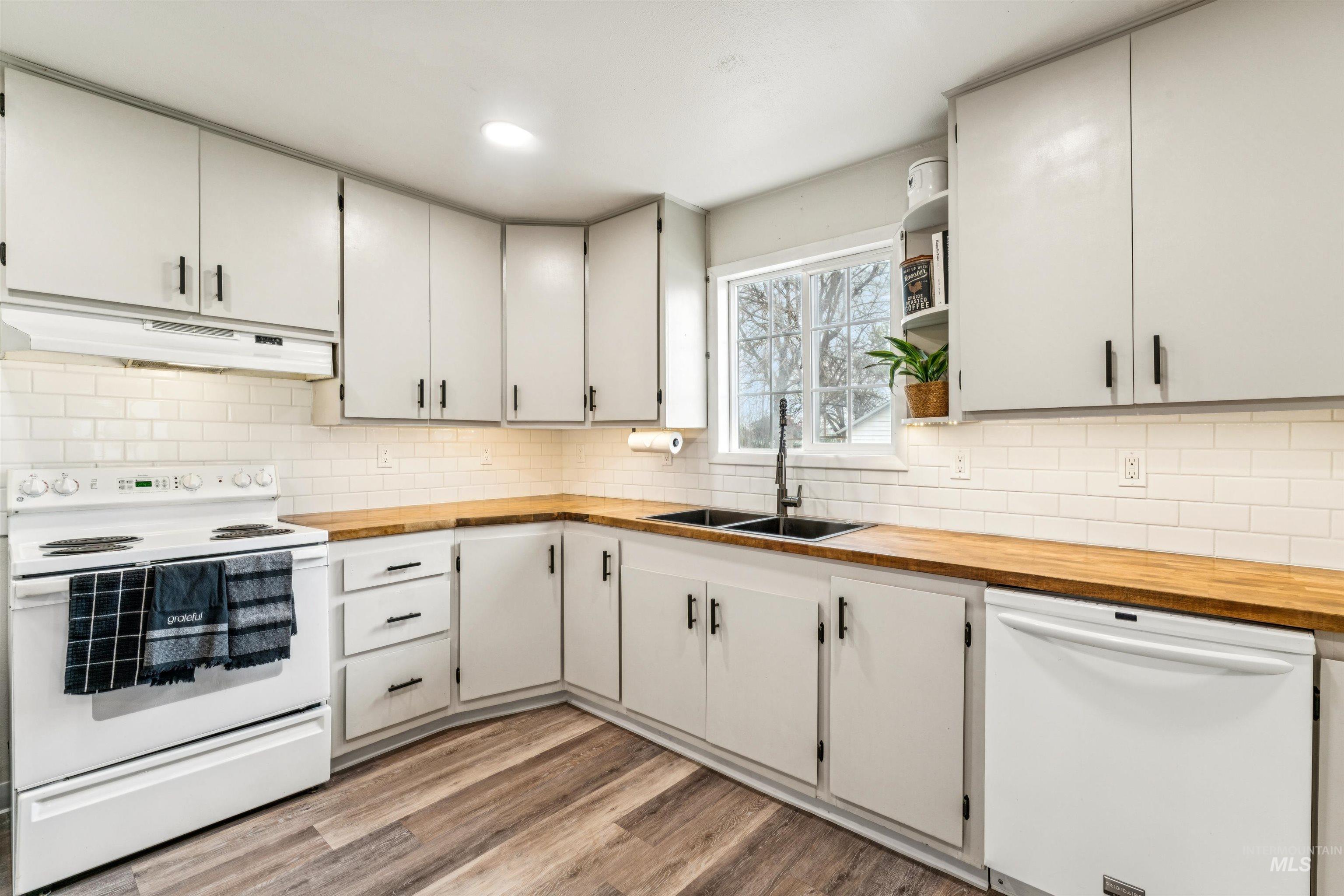 948 South Mill Road Emmett, ID 83617 - Photo 12 of 38 Kitchen with white appliances, wooden counters, light wood-style flooring, open shelves, and decorative backsplash