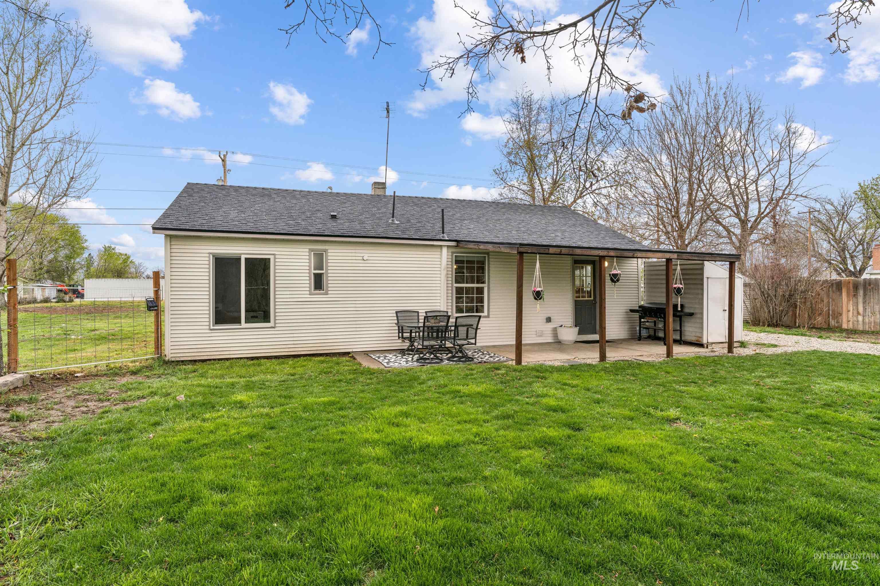 948 South Mill Road Emmett, ID 83617 - Photo 23 of 38 Rear view of house featuring a fenced backyard, a shingled roof, and a patio area