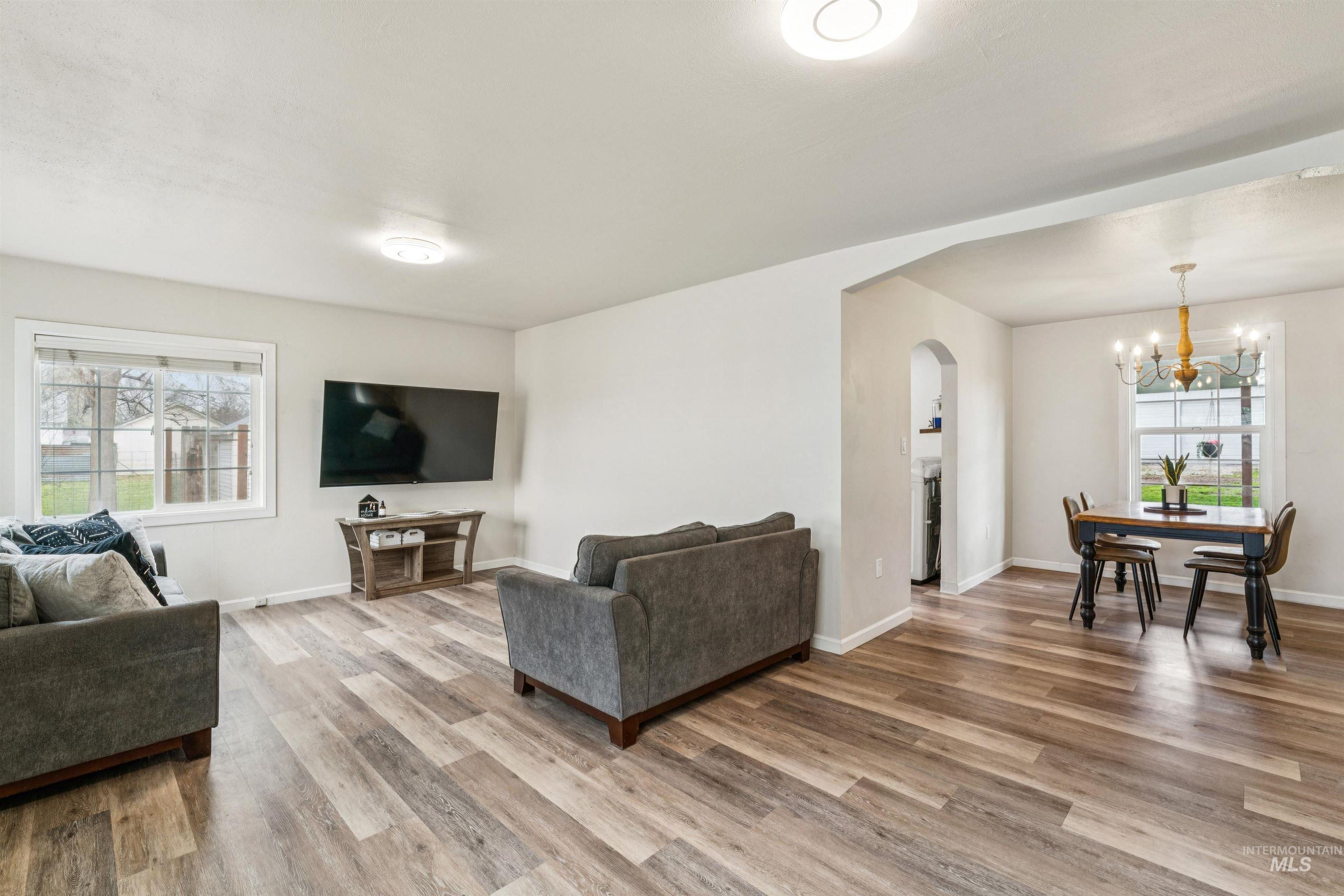 948 South Mill Road Emmett, ID 83617 - Photo 5 of 38 Living room featuring arched walkways, healthy amount of natural light, and light wood finished floors