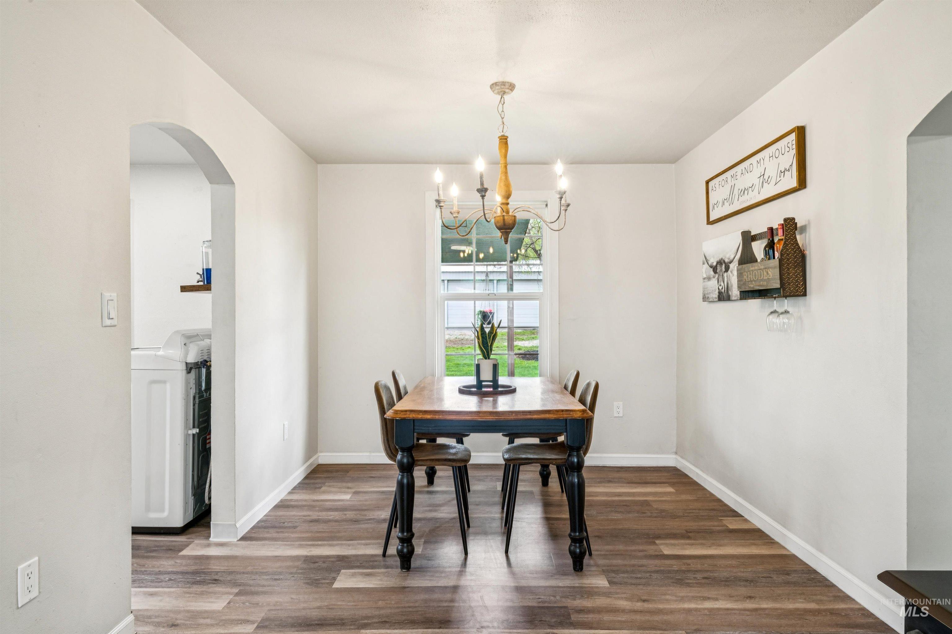 948 South Mill Road Emmett, ID 83617 - Photo 8 of 38 Dining space featuring arched walkways, dark wood-style floors, hanging lights, and washer / dryer