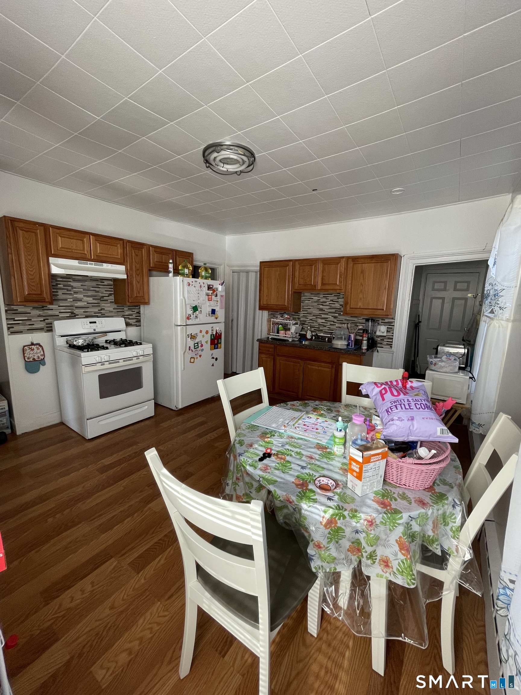 196 Park Street Bridgeport, CT 06608 - Photo 4 of 6 a view of a dining room with furniture a kitchen and chandelier
