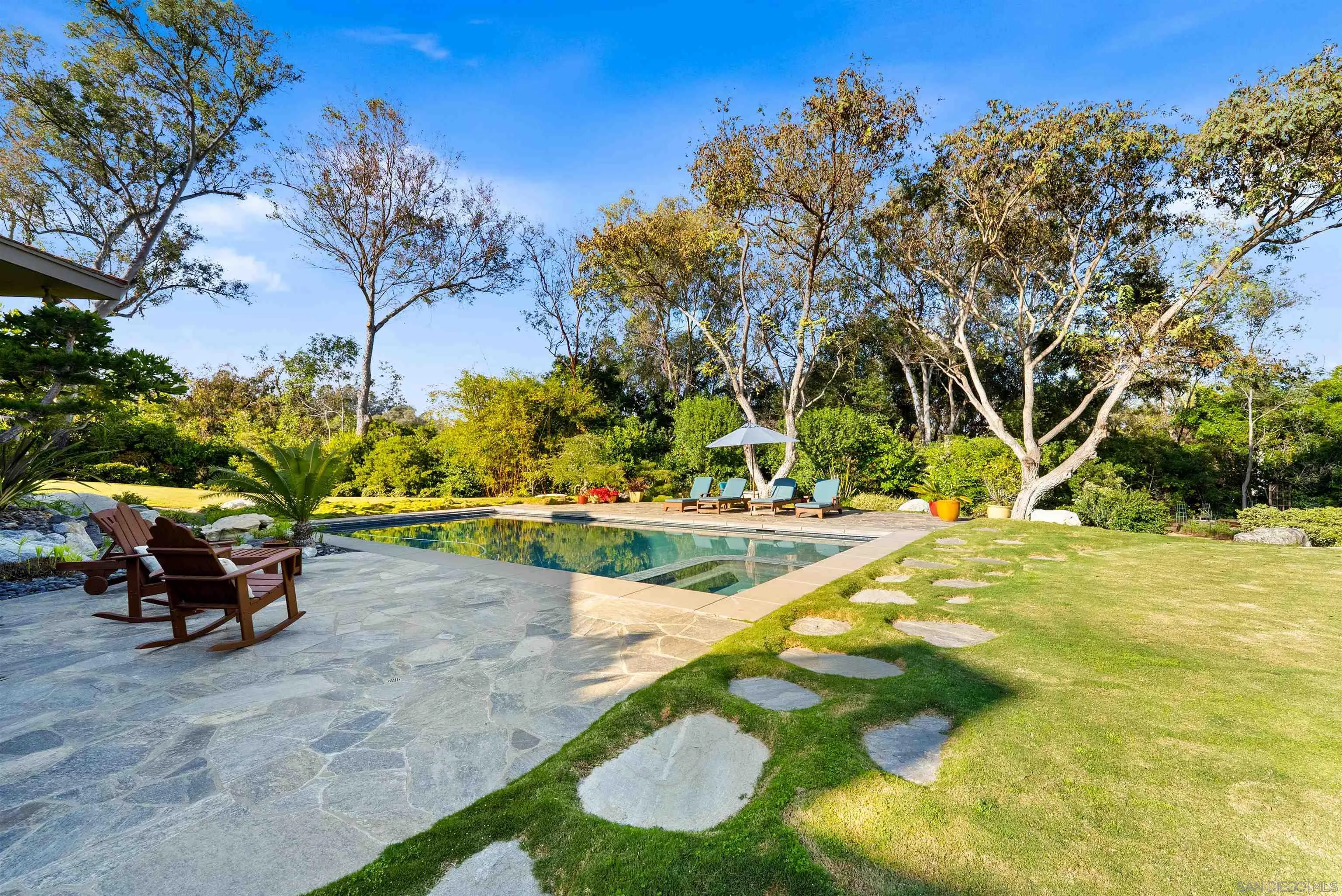5491 Calzada Del Bosque Rancho Santa Fe, CA 92067 - Photo 52 of 69 The backyard includes large grassy areas, covered patios with outdoor dining, and an outdoor fire pit perfect for enjoying the night sky
