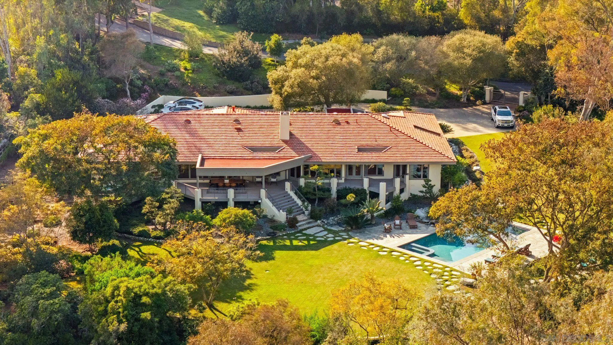 5491 Calzada Del Bosque Rancho Santa Fe, CA 92067 - Photo 66 of 69 a view of a patio with table and chairs under an umbrella with large trees